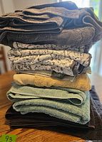 Stack of assorted bath towels showing multiple colors and pattern variety.