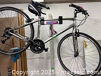 Side view of the silver Trek hybrid bike showing frame, wheels, and attached saddle bag