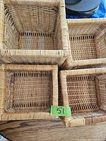 Top view of the four wicker baskets packed together on a wooden surface showing the woven pattern and size differences.