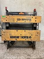Image of a Black & Decker branded wooden workbench with metal frame and clamps.