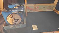 Two boxed soccer balls and sailplane kit overview