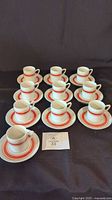 Ten cup and saucer sets arranged on surface