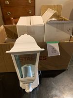 All three lantern fixtures, one unboxed in front of two boxed units