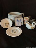 Group shot of all items: chamber pot, coaster box, Snowman plate & bowl, swan planter, floral vessel, four egg holders