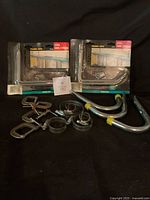 All items in lot including packaged hangers, C-clamps, hose clamps and curved hooks