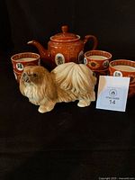 Group shot showing teapot, six bowls (stacked) and Pekingese figurine
