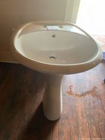 Full front view of pedestal sink showing complete item