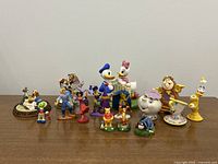 Wide view of all Disney figurines and sculptures arranged showing characters from various classic Disney franchises.
