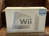 Closed original Nintendo Wii box showing image of the console and Wii Remote, and Wii Sports game sticker.