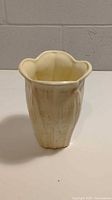 Front view of Haeger ivory/cream ceramic vase showing wavy floral rim and textured surface.