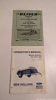 Oliver Disc Harrows manual and New Holland Manure Spreader operator's manual side by side on a surface.