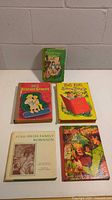 Five vintage children's books arranged on a floor against a wall, showing their front covers with titles and colorful illustrations.