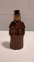 Front view of the ceramic coachman decanter showing detailed facial features and coat with buttons, top hat included.