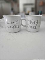 Both mugs front view showing lettering and speckled finish