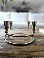 Side view of metal 4-light candelabra showing two candle cups and oval base