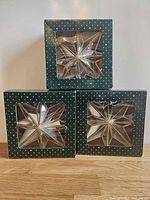 Three boxed mirrored star ornaments stacked