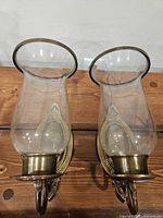 Front view of both brass sconces with glass shades