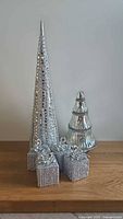 All items together: cone tree, mercury glass tree, four silver present ornaments