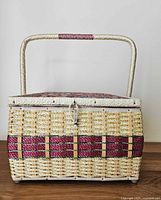 Front view of rectangular wicker sewing basket showing clasp, woven pattern and handle