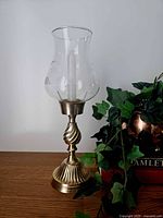 Full view of brass hurricane candle holder with etched glass shade