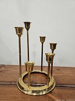 Front view of brass circular candelabra showing six graduated holders