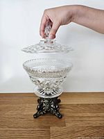 Full view with lid being removed, showing glass bowl, lid, metal base