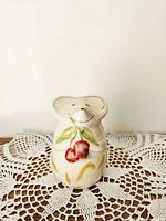 Front view of ceramic mouse shaker on lace mat