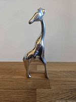 Front view of polished aluminum giraffe sculpture