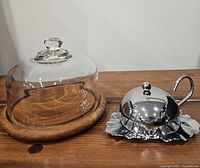 Teak cheese board with glass dome beside maple leaf butter dish assembled