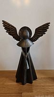 Full view of bronze angel sculpture with wings and halo