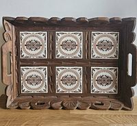 Top view showing carved wood frame, six patterned tiles, handles and border detailing