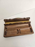 Top view showing open hinged compartment with yellow felt interior and four front compartments