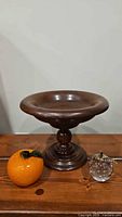 Group shot of wooden pedestal bowl with glass apple and orange