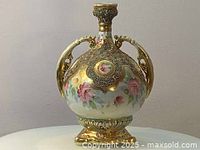 Front view of antique round floral hand painted vase with gilded gold accents and two loop handles.