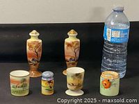 Full set image showing two tall pepper shakers and four small cups alongside water bottle for size reference