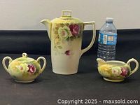 Full view of the coffee pot, sugar bowl, and creamer displayed side by side with a water bottle for size reference.