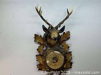 Full view of the French Fisher barometer mounted on a carved wooden plaque with oak leaves and deer head with antlers.