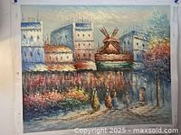 Full view of oil painting on canvas showing a cityscape with buildings and a windmill in the background, people and foliage in the foreground.
