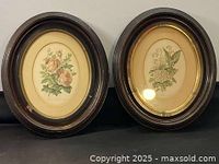 Photo showing pair of oval Victorian floral pictures in dark walnut frames, signed and aged with light wear on frames.
