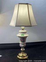 Front view of the full lamp showing fabric shade and porcelain base with floral design.