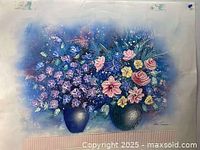 Front view of a still life painting depicting two vases filled with blue, pink, purple, yellow, and white flowers on a blue background.