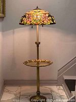 Full view of Tiffany style floor lamp with brass table base