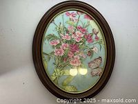 Vintage floral picture in oval wooden frame with glass, showing the full image of flowers and butterfly.