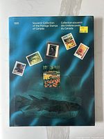 Front cover of the 1991 Souvenir Collection of Canadian Postage Stamps book showing blue background with images of five sample stamps and value sticker.