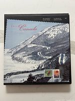 Cover of the stamp collection book showing a snowy mountain scene and two featured stamps.