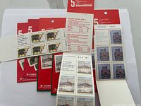 Six booklets of Canada postage stamps laid out overlapping, showing the stamps and booklet covers clearly.