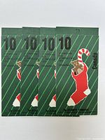 Four booklets of 10-cent Canadian Christmas stamps showing teddy bear in stocking laid side by side