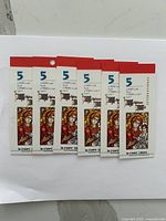 Six booklets of 5 cent Canadian stamps featuring stained glass style artwork.
