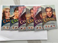 Six colorful Canada postage stamp booklets arranged overlapping showing cover artwork mainly of portraits of individuals under the theme Canadians in Hollywood.