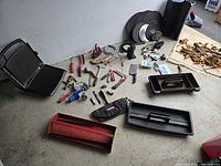 Overview of all items spread on floor including Breville grill, toolbox trays, various hand tools, circular blades